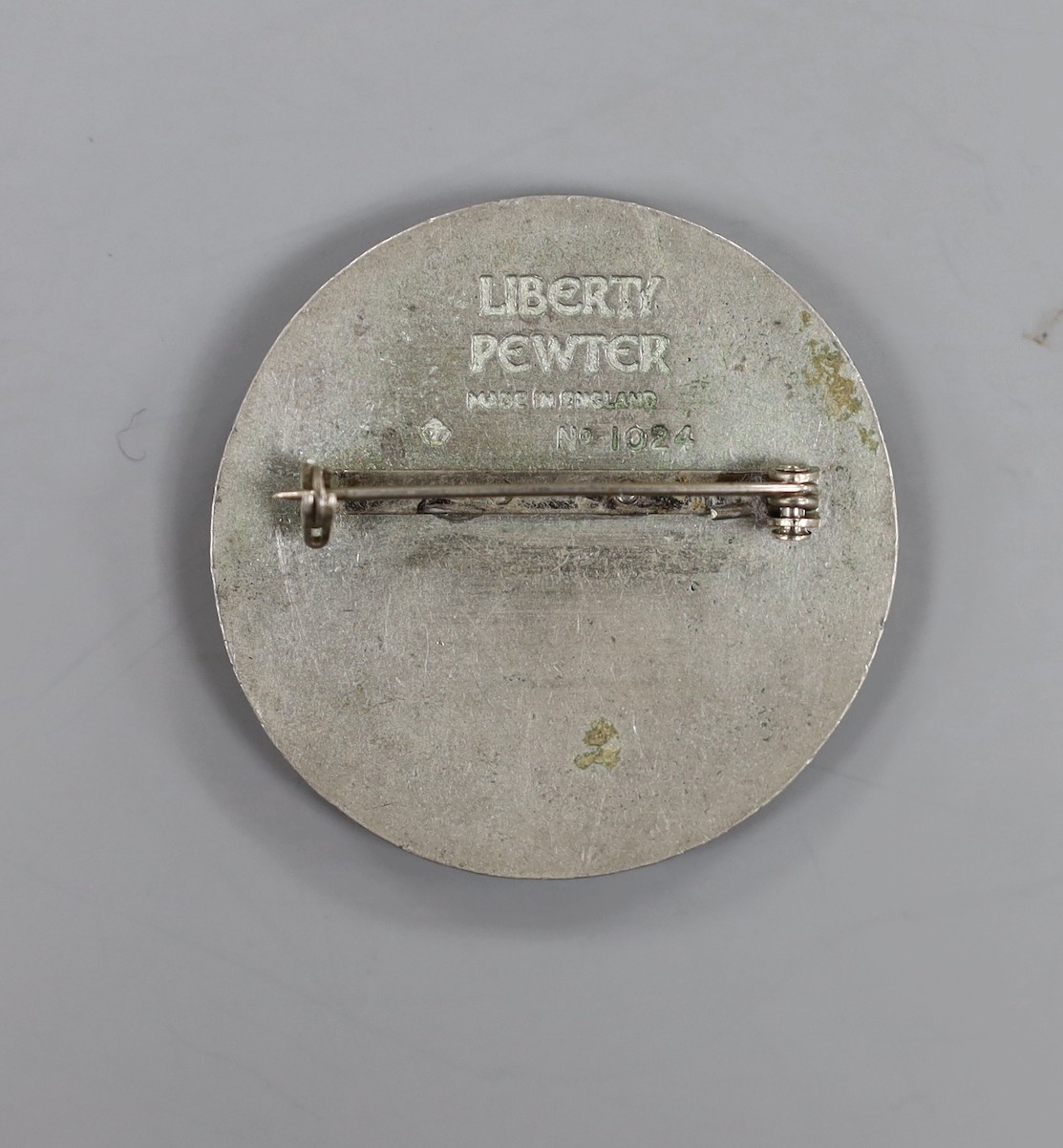 A Liberty pewter and planished copper circular brooch, no. 1024, 47mm.